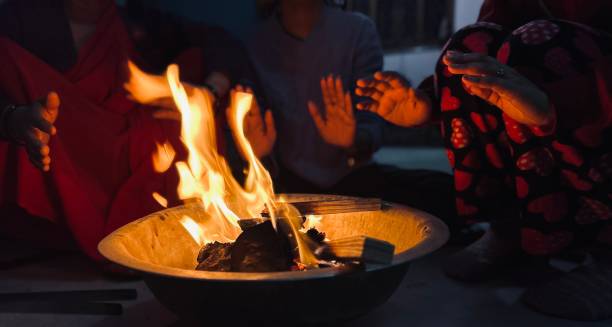 istock People warming hands while sitting around a bonfire in winter at home. 1931733095