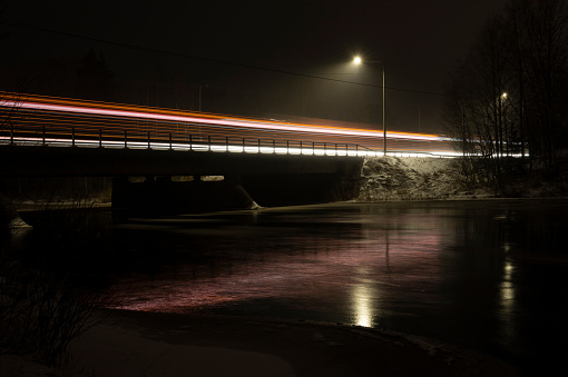 Light trail of traffic on a bridge over a river