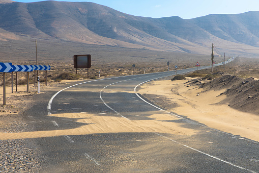 Country road with sand dunes to Caleta Famara in the Chinijo Natural Park near the village Teguise. Lanzarote, Spain, Europe