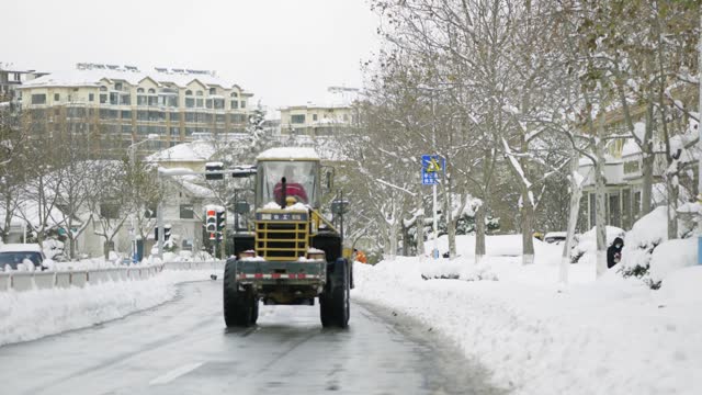 A large forklift is clearing snow