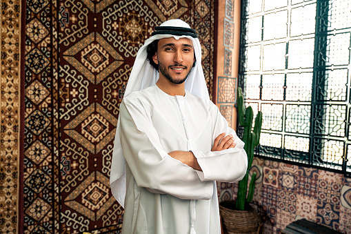 Man from emirati wearing kandura outfit spending time in an arabian traditional house in Dubai