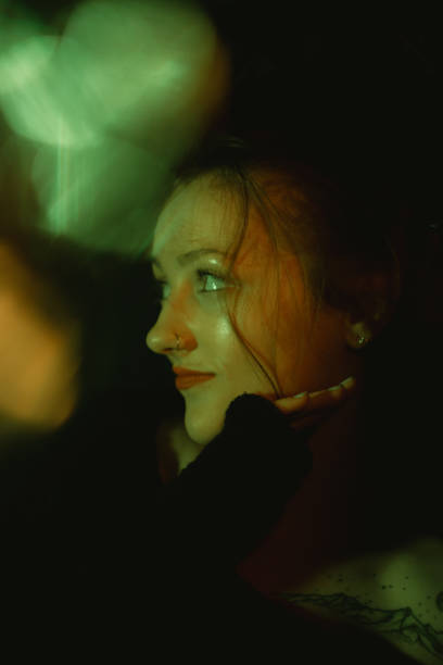 istock woman looking up to her right with dark background, looking over shoulder 1931874538