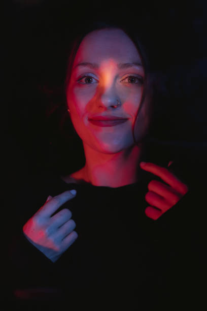 istock woman in a black top with red light coming through her eyes 1931875055