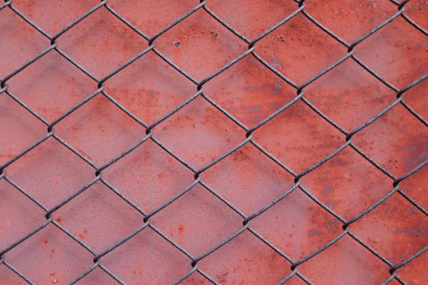 Chain link fencing mesh or wire gauze and red painted metal with rusty on surface background.