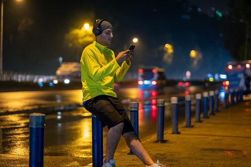 Fitness man taking a break after exercise. and I'm looking at the phone.