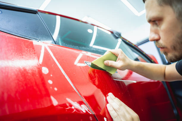 istock The process of installing protective film on the new red car. 1931900915