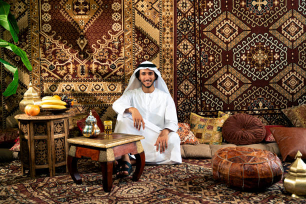 Man from emirati wearing kandura outfit spending time in an arabian traditional house in Dubai