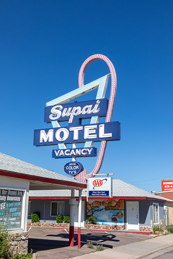 Seligman, USA - May 25, 2022: Motel and Route 66 sign Supai on Historic Route 66. Built in 1904. The neon light lost color but is still in use.