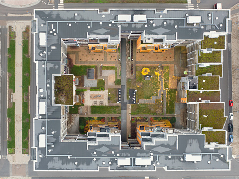 Top down view of modern apartment buildings with a courtyard in the center and partially plant covered roofs outside Stockholm in autumn.