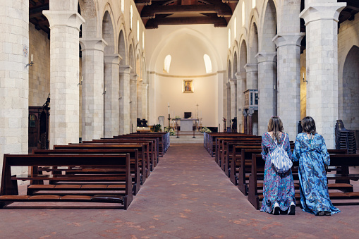 Teenage girl and her mother praying at church.\nShot with Canon R5