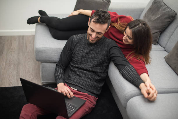 istock Happy couple using a laptop computer in their house 1932035891