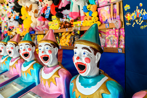 A carnival game with a line of clowns with open mouths ready for balls.