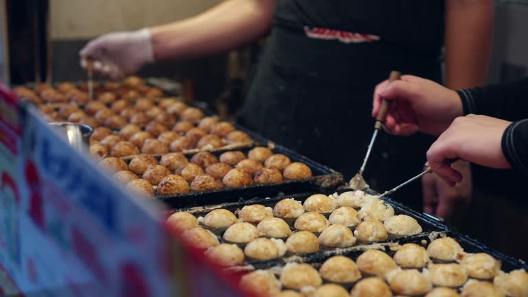 Chef cooking Japanese food Takoyaki at street market in Japan.