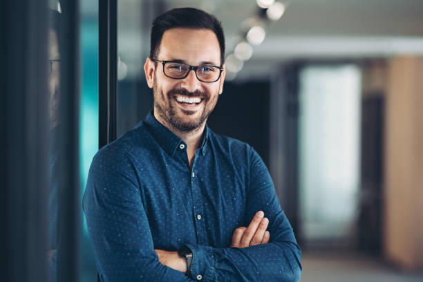 Retrato de um jovem empresário de pé com os braços cruzados - foto de acervo