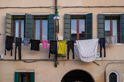 On a sunny day, colorful laundry hangs on the wall of the house to dry in typical Italian fashion.