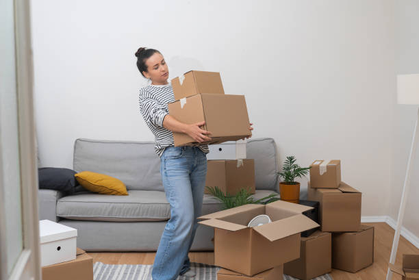 istock Female carries cardboard boxes with supplies for moving 1932093846