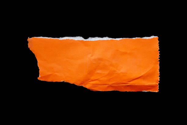 istock Ripped orange paper piece isolated on black background 1932116110