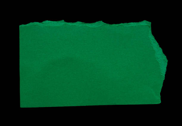 istock Ripped green paper piece isolated on black background 1932119715