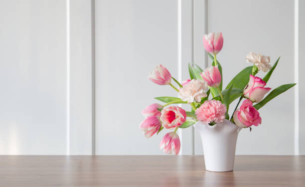 istock pink spring flowers in white ceramic vase in modern home interior 1932144416