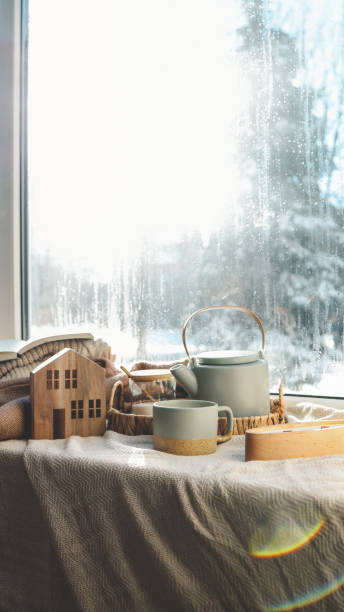 istock Cozy winter home interior, candle, tea and teapot on the windowsill 1932155047