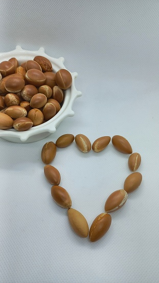 Argan seeds in a heart shape on a white background.