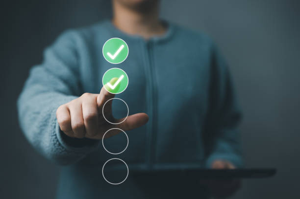 istock Woman tick correct sign mark in checkbox for quality document control checklist and business approve project concept. Online test, Checkmark, Filling out digital form checklist, online exam technology 1932178172
