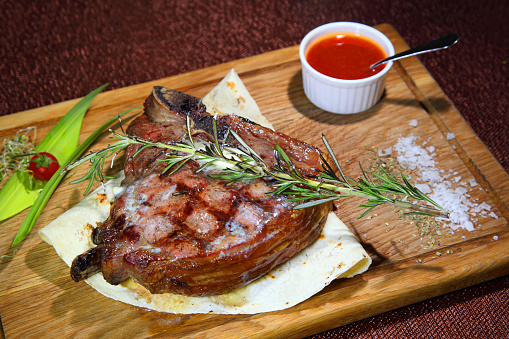 Medium-roasted. Medium-roasted steak cut into pieces on a wooden board.