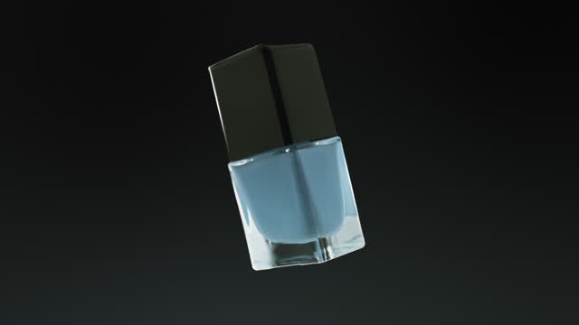 Glass container with nail polish spinning and changing colors cut out on blue gradient background.