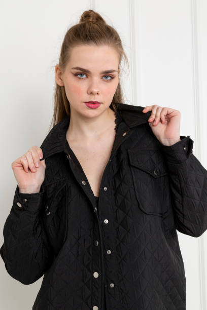 istock Blonde young woman wearing black coat. 1932212972
