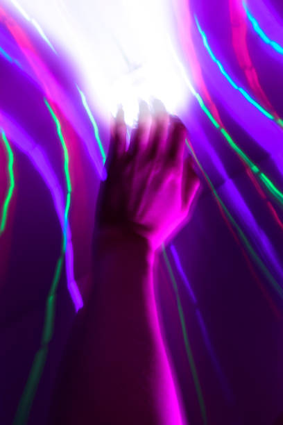 istock Women Hand Touching Beam of Purple Light 1932238426