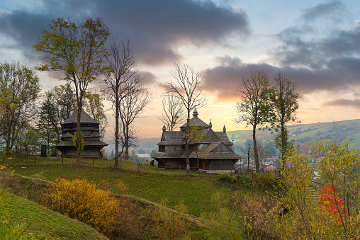 Traditional wooden church in the mountain valley. Picturesque landscape in Carpathian mountains.