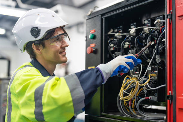 istock Happy engineer electrical man wearing helmet safety protection installing wire cable and breaker switch electric control in cabinet. 1932258131