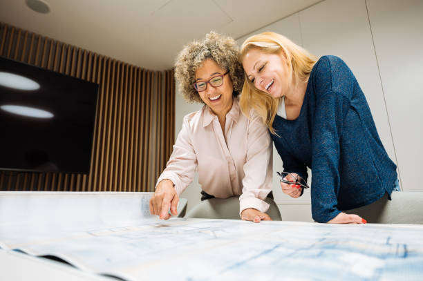 istock Business women and teamwork in modern corporate office, partners checking blueprint 1932272064