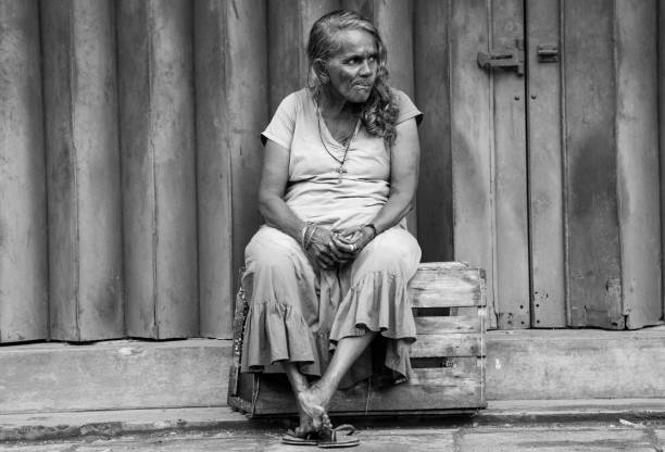 Black and white portrait of an elderly woman laughing openly and warmly. Closed eyes, deep smile lines, and a natural posture convey authenticity, joy of life, and emotional strength beyond age-related stereotypes.