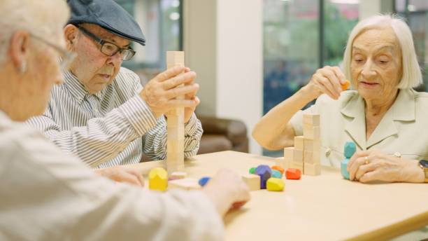 istock Concentrated seniors resolving brain skill games with pieces in geriatric 1932296659