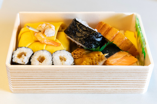 A sm all wood travel sushi box as sold in train stations.