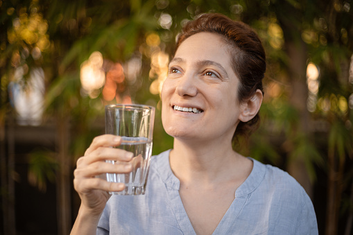 Caucasian woman taking a sip of cold water after removing the ice, relieved , part of a series for sensitive teeth