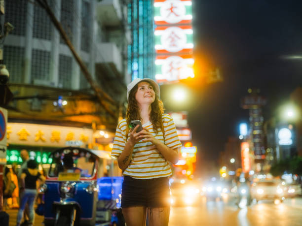 istock Woman using smartphone while exploring Chinatown in Bangkok during vacation 1932365832