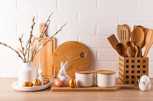 Eco-friendly kitchen utensils, wooden cutting boards, vase with willow twigs, Easter decorations. Eco style. Front view