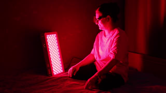 Senior Woman doing the Red Light Therapy Session with Panel at home