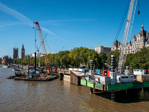 Construction work on part of the Thames Tideway ‘super-sewer’ which is being built for 16 miles (25km) beneath the River Thames in London in order to catch, store and convey any sewage and rainwater which currently pollutes the river on occasions. It is due to be completed in 2023 and will run from Acton in West London to Beckton Sewage Treatment Works in East London. This section is beside the Victoria Embankment near Blackfriars. (Incidental people.)