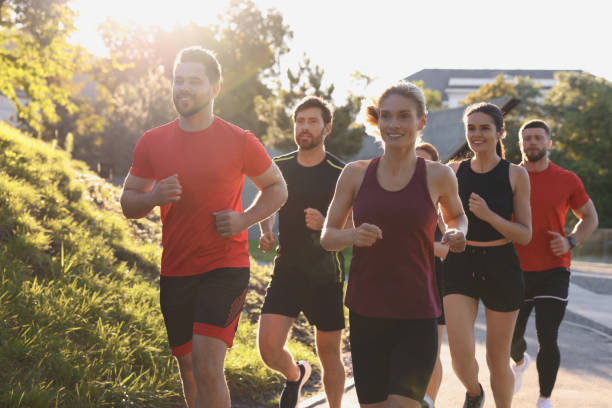 istock Group of people running outdoors on sunny day 1932547073