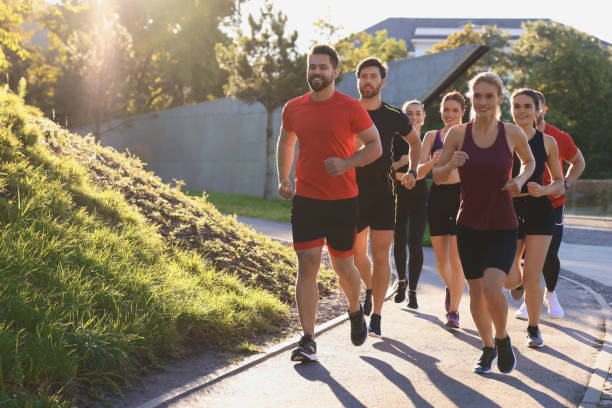 istock Group of people running outdoors on sunny day. Space for text 1932547075