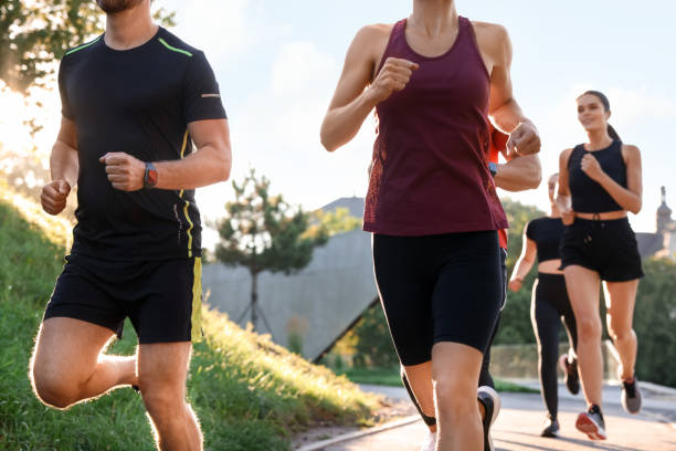 istock Group of people running outdoors on sunny day 1932549262