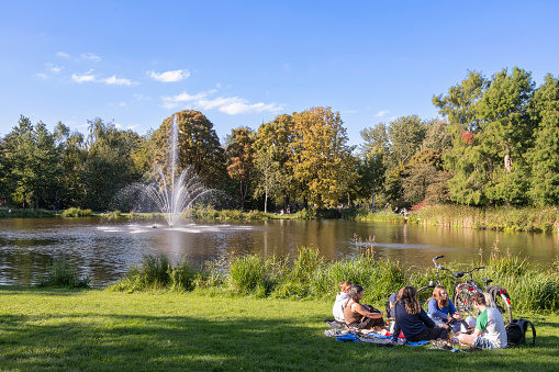 Amsterdam, Netherlands, September 24, 2023; Young people enjoy the beautiful weather along the water in the Vondelpark in Amsterdam.