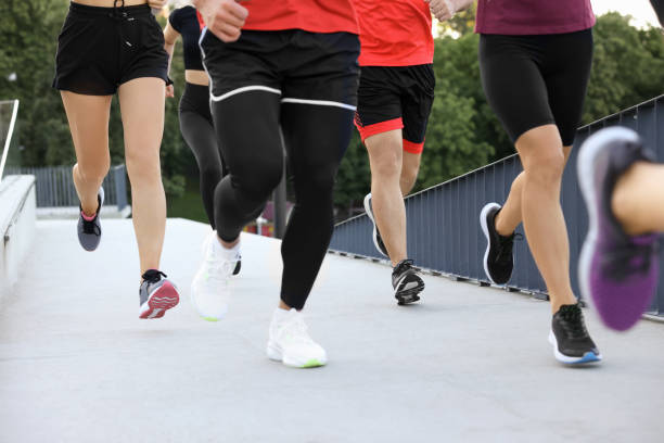 istock Group of people running outdoors, closeup view 1932551442