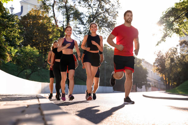 istock Group of people running outdoors on sunny day 1932569075