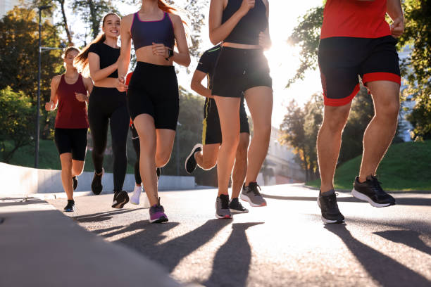 istock Group of people running outdoors on sunny day 1932569087