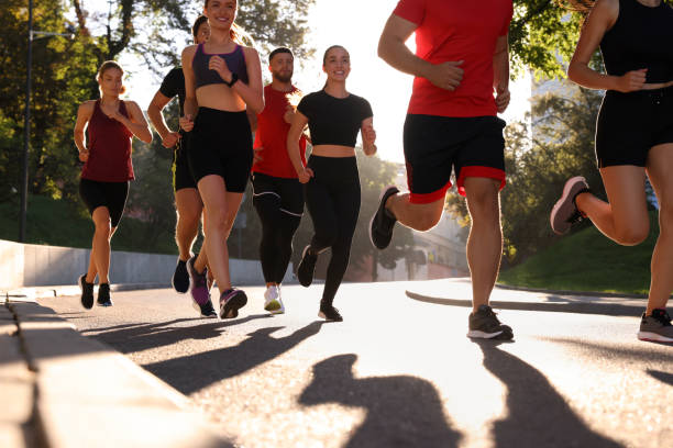 istock Group of people running outdoors on sunny day 1932570179
