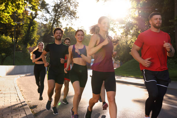 istock Group of people running outdoors on sunny day 1932570181
